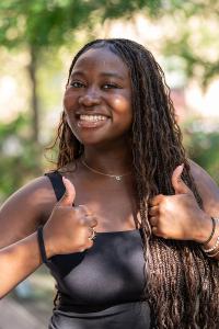 A smiling woman gives a double thumbs-up sign